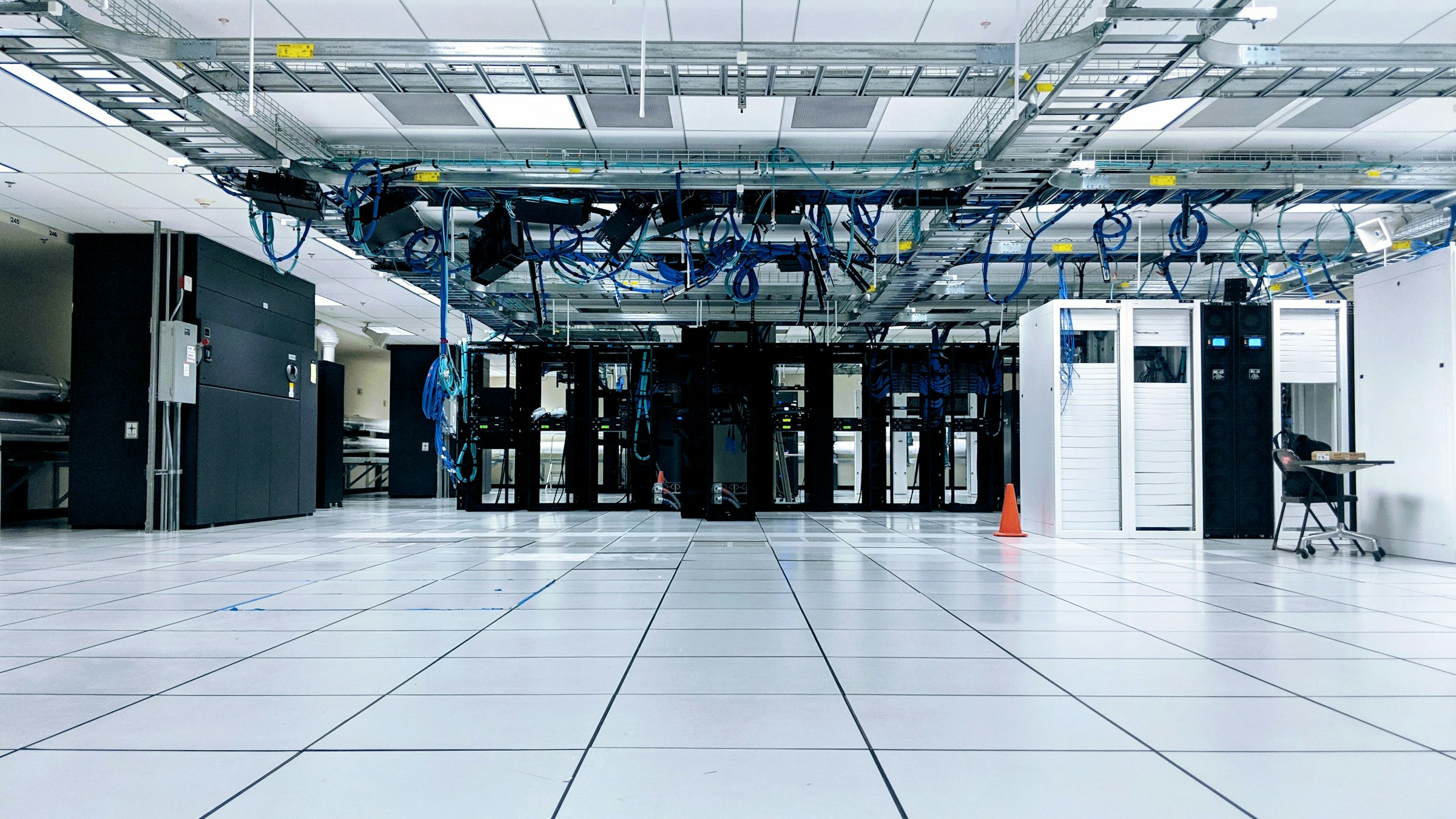 Serverraum mit Netzwerkschränken und blauen Kabeln